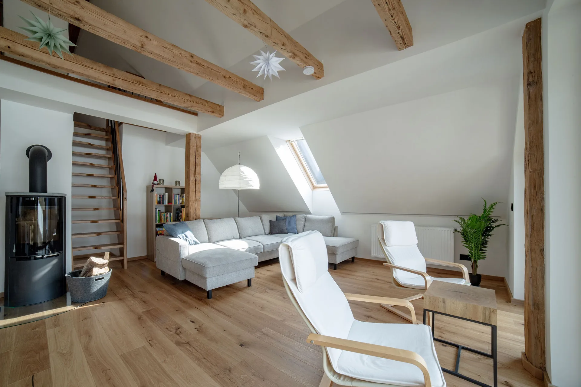 Wohnzimmer im Dachgeschoss mit Kaminofen und Leseecke für gemütliche Stunden mit Bergblick.